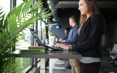 a woman sitting at a table using a laptop computer