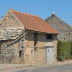 an old stone building with a red roof