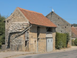 an old stone building with a red roof