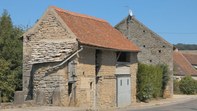 an old stone building with a red roof