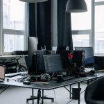 Un bureau moderne avec plusieurs écrans, chaises et lumière naturelle