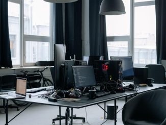 Un bureau moderne avec plusieurs écrans, chaises et lumière naturelle