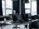 Un bureau moderne avec plusieurs écrans, chaises et lumière naturelle