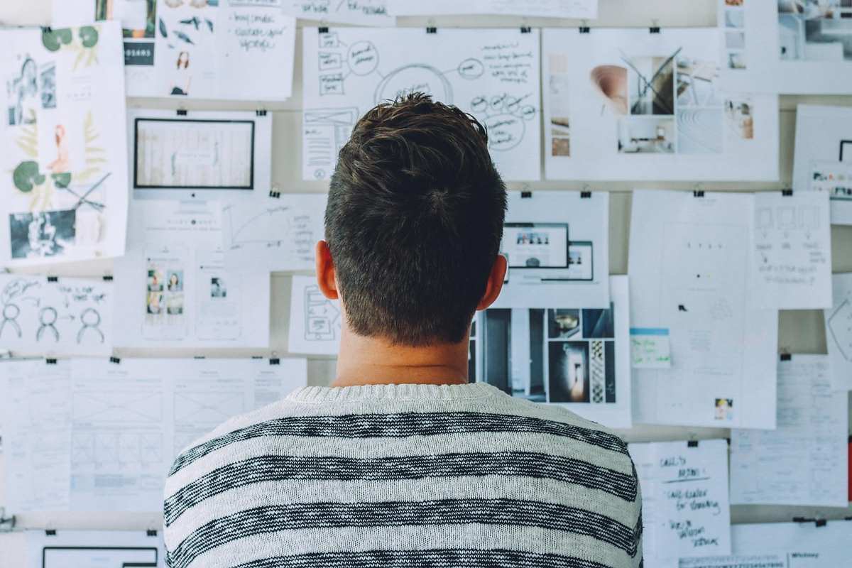 Un homme regarde un tableau de notes et de photos